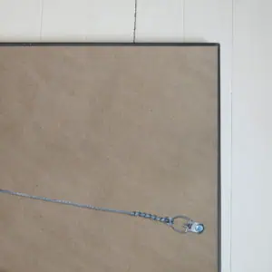 A keychain with a silicon heart-shaped keyring attached to a metallic chain, resting on a cork bulletin board, with a white wooden wall in the background. Ideal for key organization and home or office décor.