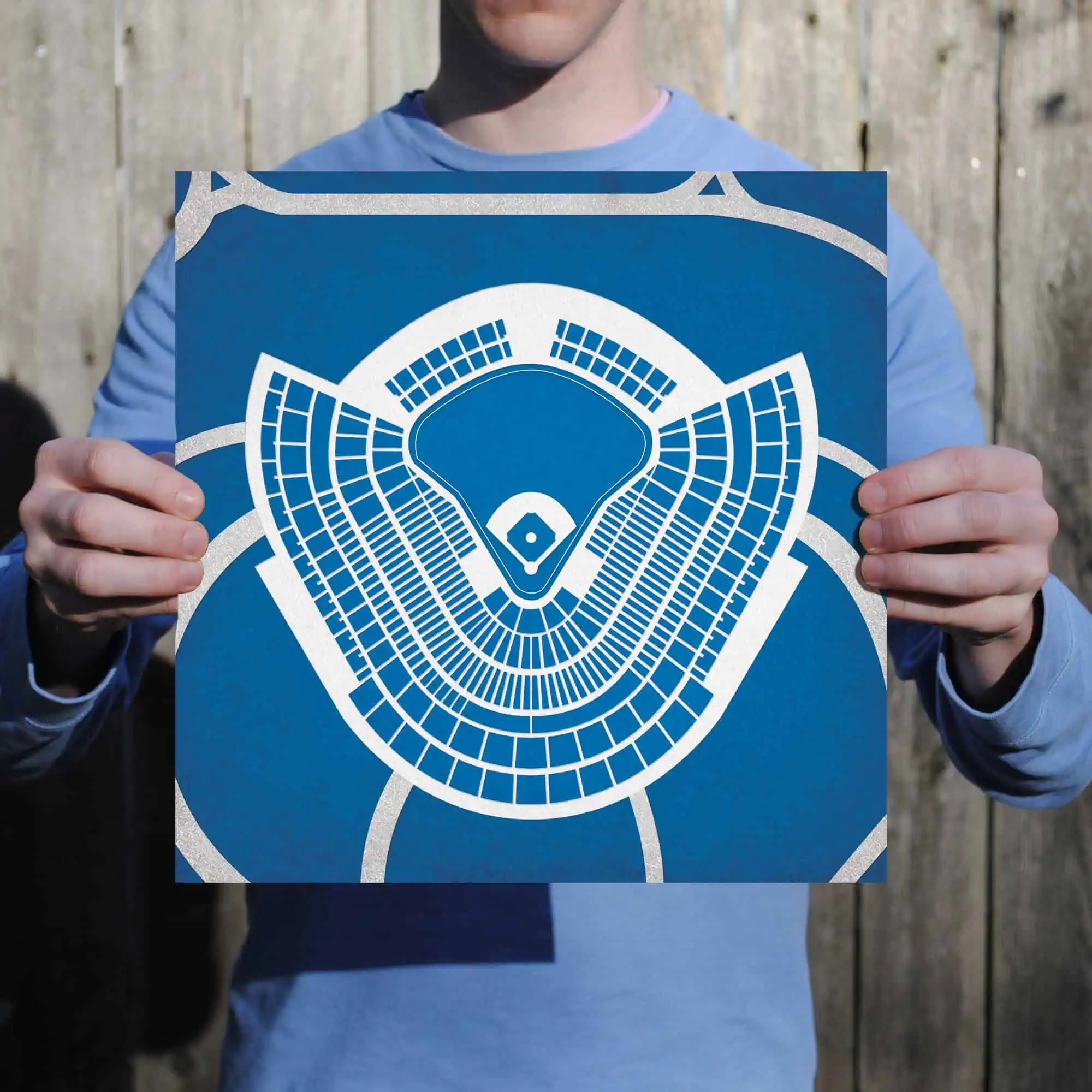 Blue baseball stadium seating chart map held by person outdoors.