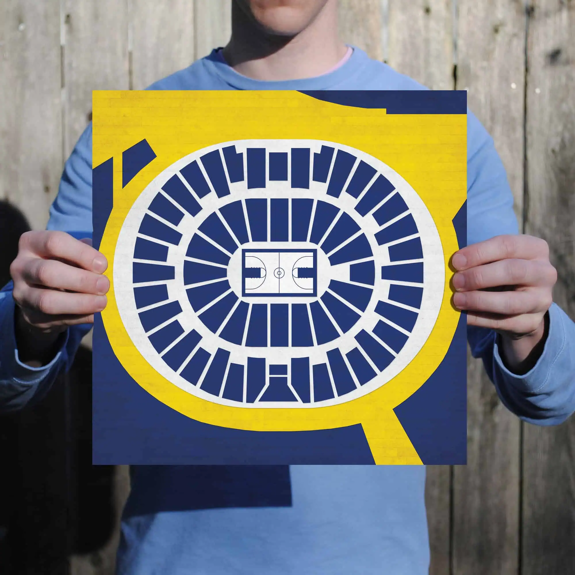 Blueprint of a sports stadium, featuring vibrant yellow and navy design, being held by a person. Ideal for sports arena maps, stadium seating plans, and sports venue navigation.