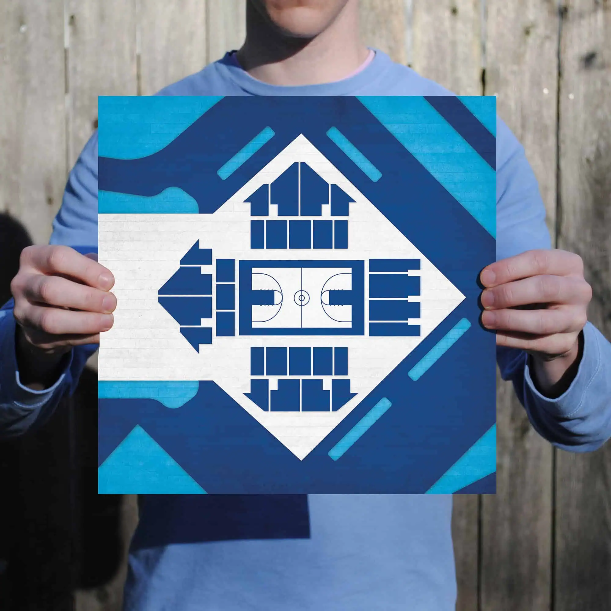 Colorful blueprint of a soccer field and surrounding facilities held by a person outdoors.
