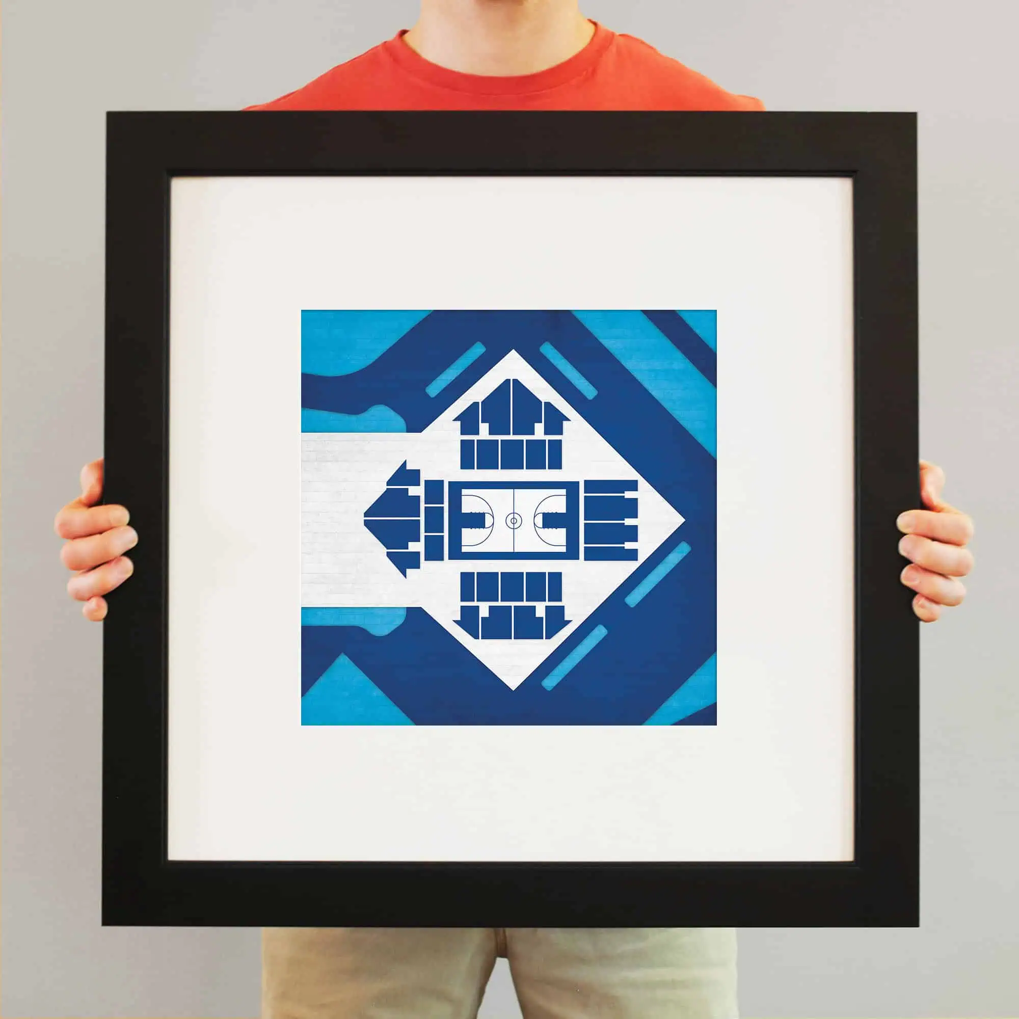 Colorful digital artwork of a sports arena, featuring blue tones and geometric design elements, framed and being held by a person standing against a plain background.