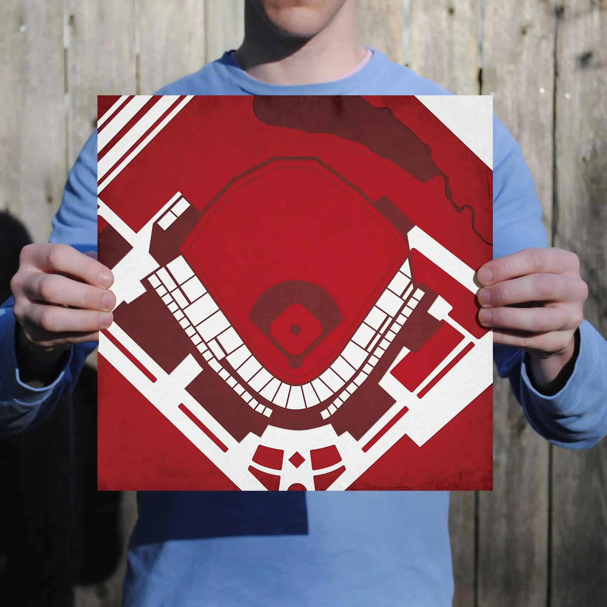 Blue jacket person holding a stadium blueprint architectural map for sports venue design and planning.