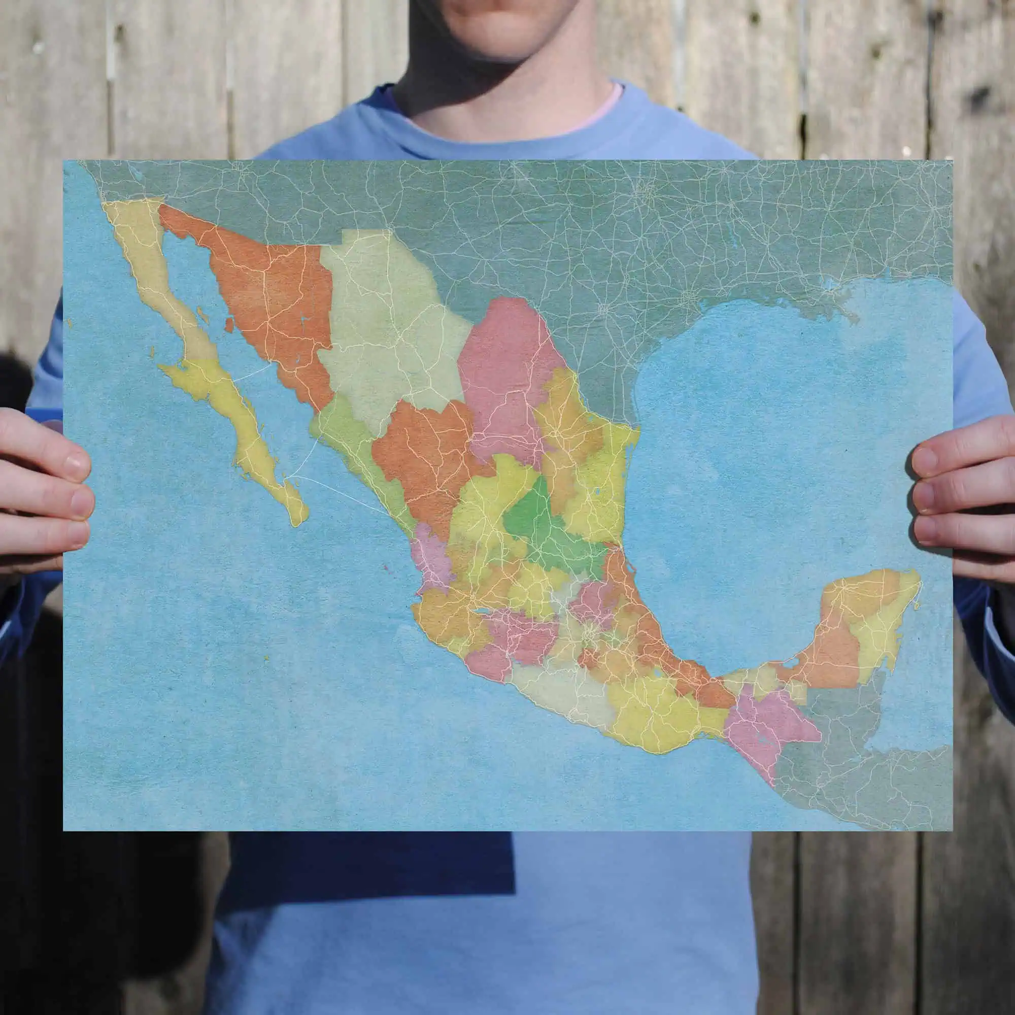 Colorful map of Mexico showing its states and geographical features, held by a person outdoors for travel, geography, or educational purposes.