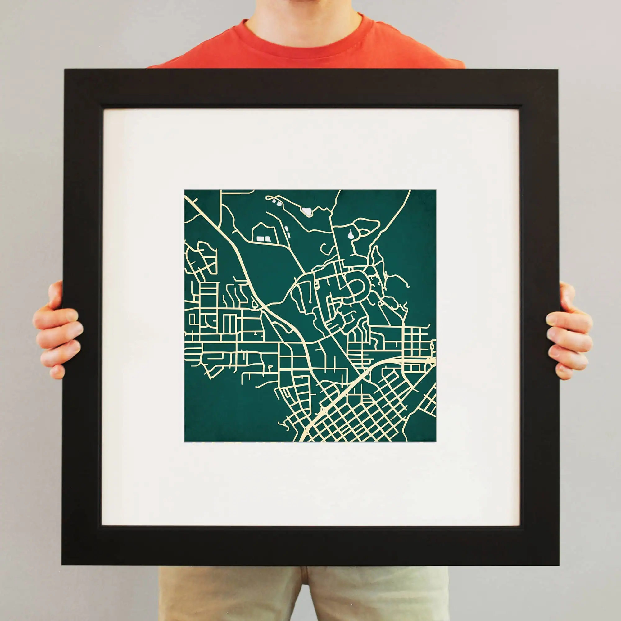 Detailed map artwork of an urban cityscape printed on paper, held in a black frame. The map features intricate street layouts and geographical features, ideal for wall decor or as a travel-inspired art piece.