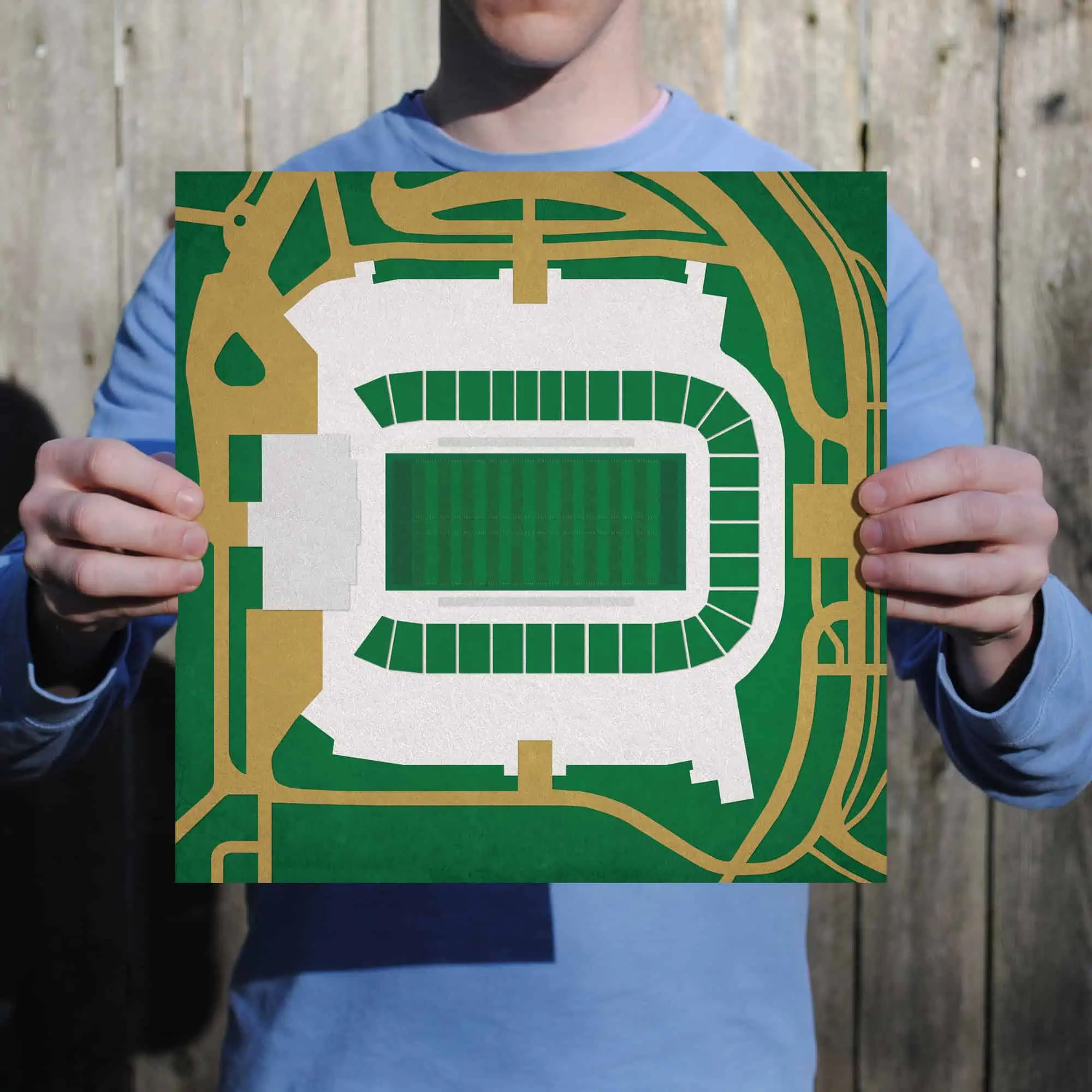 A person holding a detailed stadium layout map with surrounding roads, perfect for sports event navigation and travel planning.