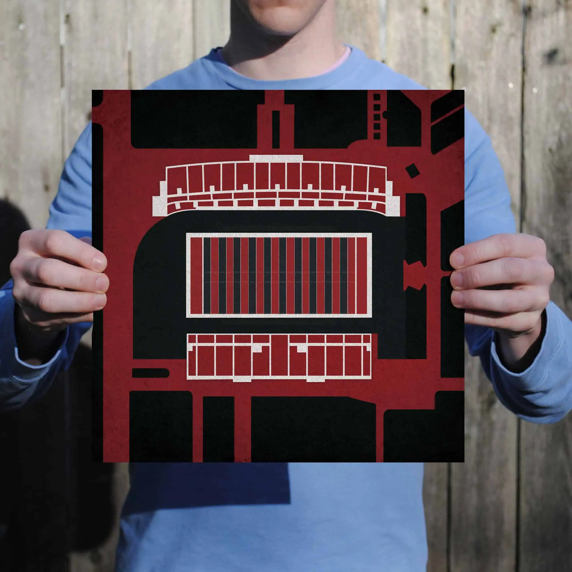 Colorful, abstract cityscape map artwork in red, black, and white, held by a person outdoors, emphasizing urban exploration, travel, and navigation themes for the map shop.