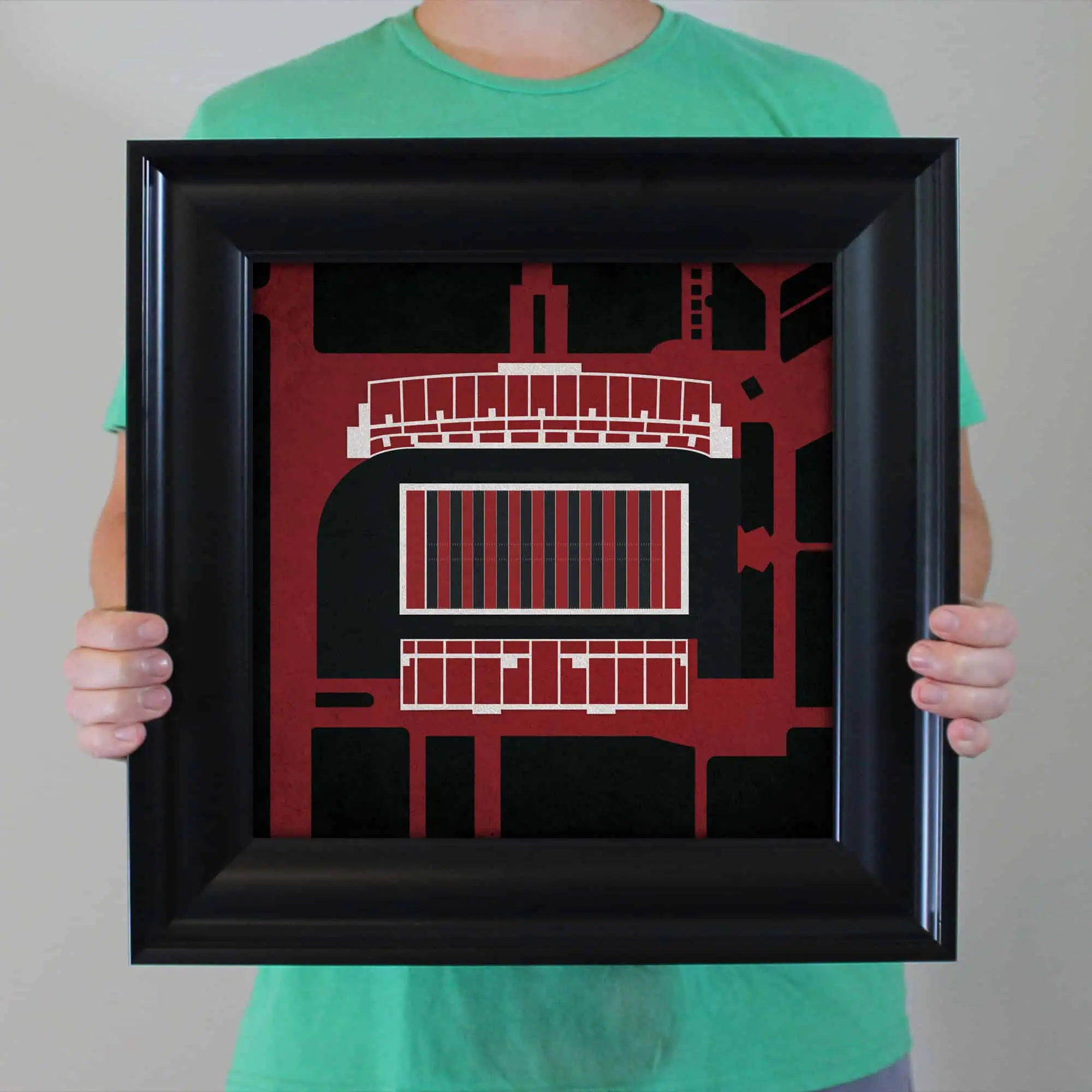 A framed abstract cityscape artwork featuring bold black, red, and white geometric shapes, perfect for modern home or office decor emphasizing urban design themes.