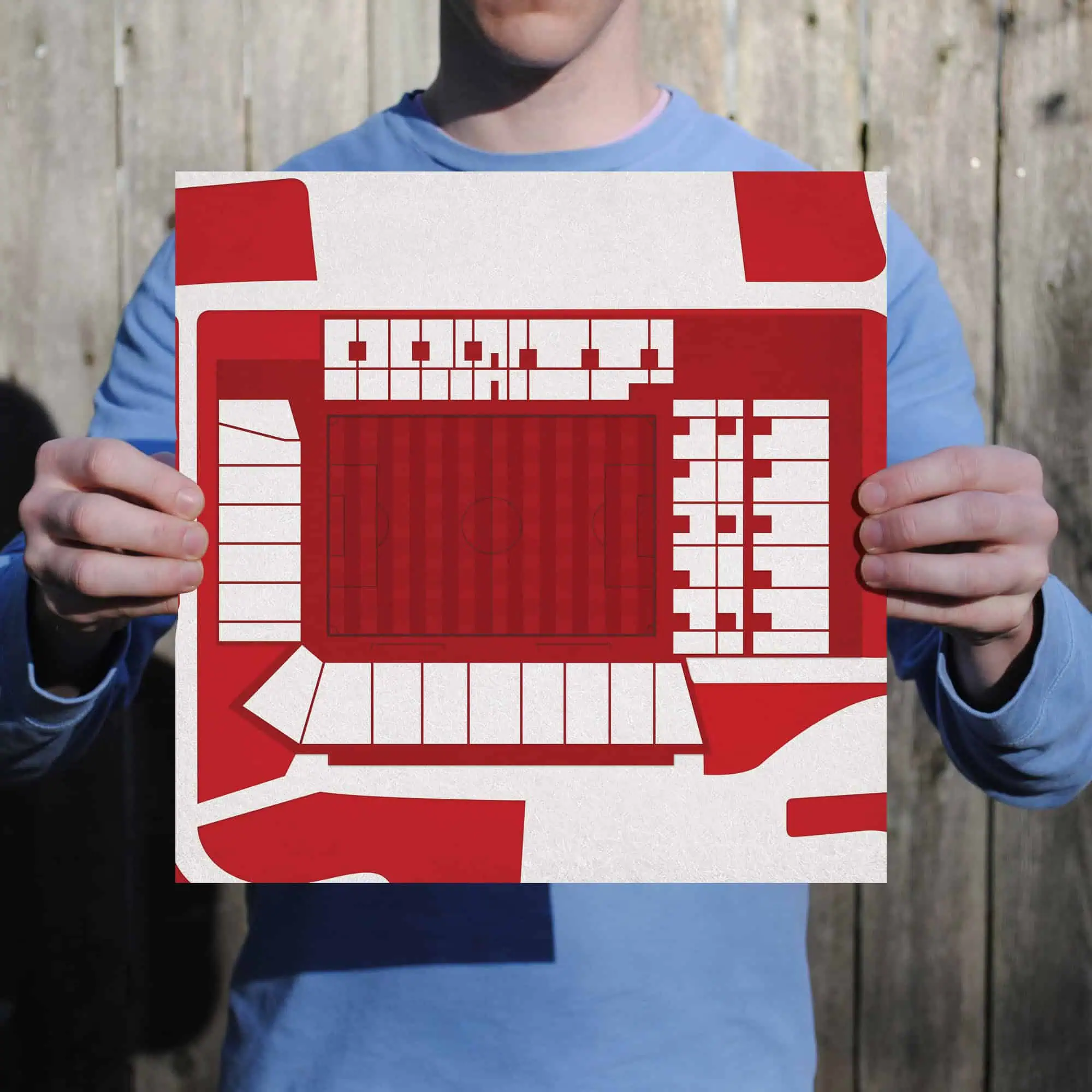 Bird's-eye view of a person holding a red and white stadium seating chart, representing a sports arena map for fans and visitors, perfect for sports and event venue guides.