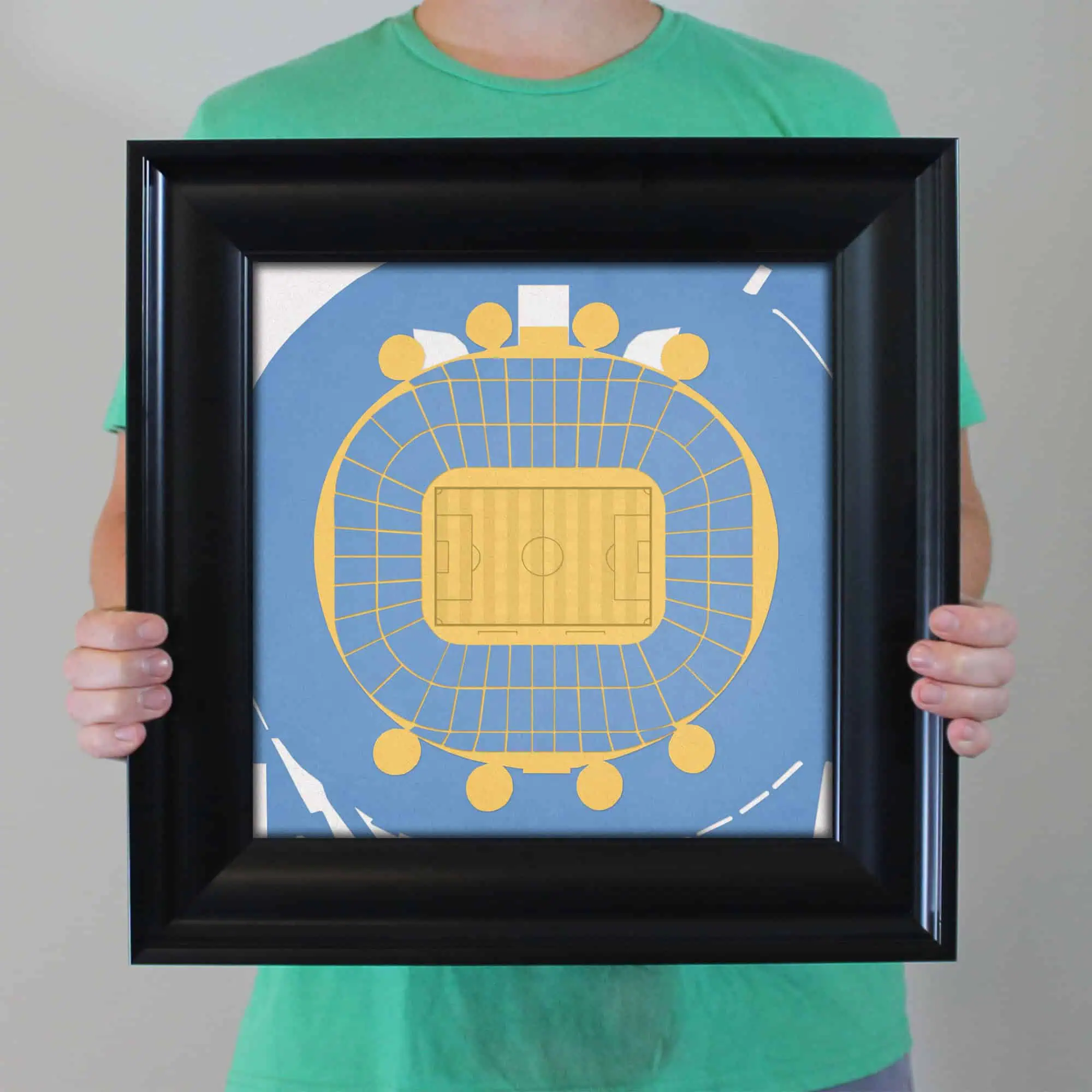 High-angle view of a framed sports stadium map, showcasing detailed seating and field layout, ideal for sports fans, event planning, and venue navigation.