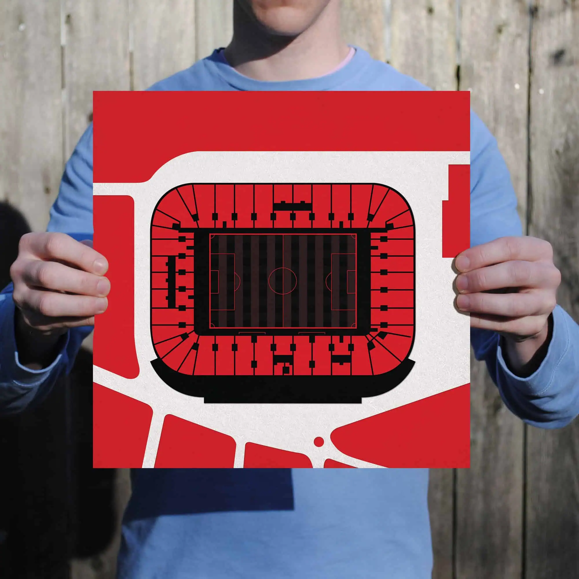 Stadium map print held by a person, featuring seating arrangements and field layout, perfect for sports venue navigation and event planning.