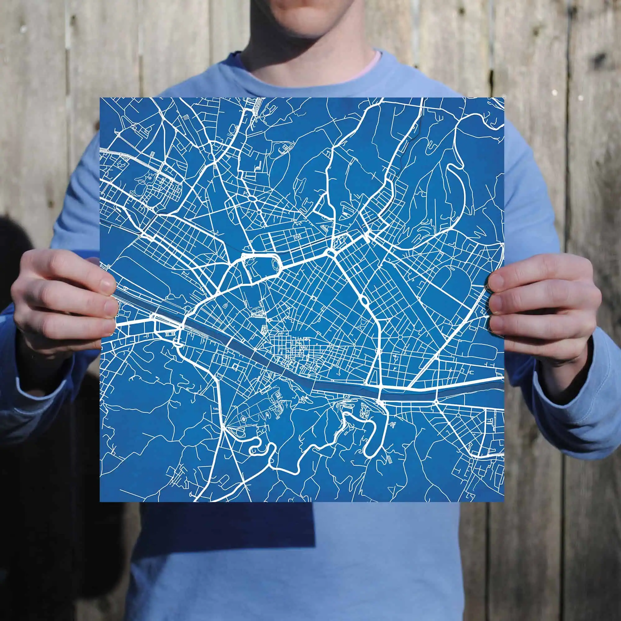 Detailed city map held by person, showcasing urban streets and road networks for navigation and geographic reference.