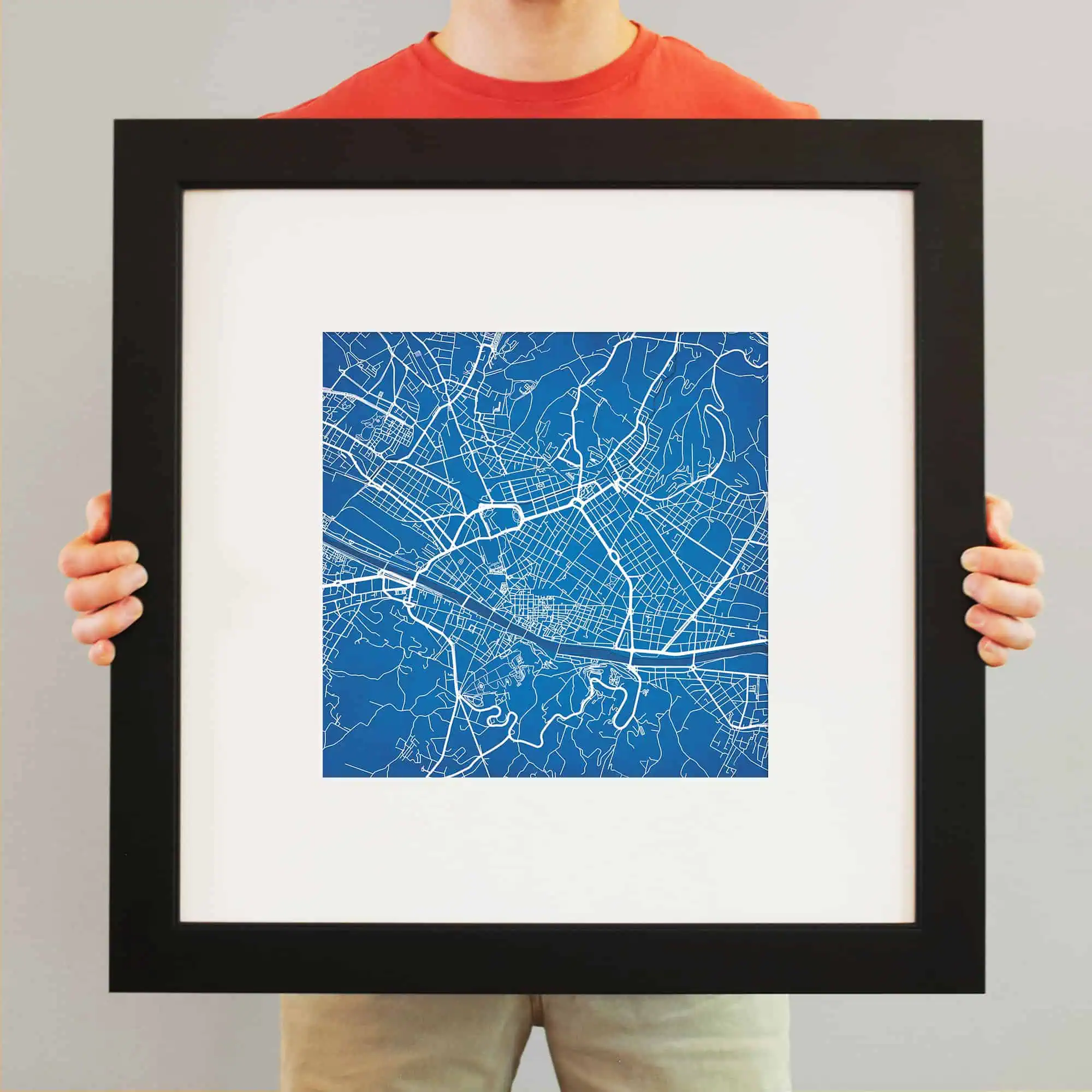 Intricate city map art print in a black frame, showcasing detailed street layouts and geographic features for urban navigation and decor. Perfect for map enthusiasts or modern home decor.