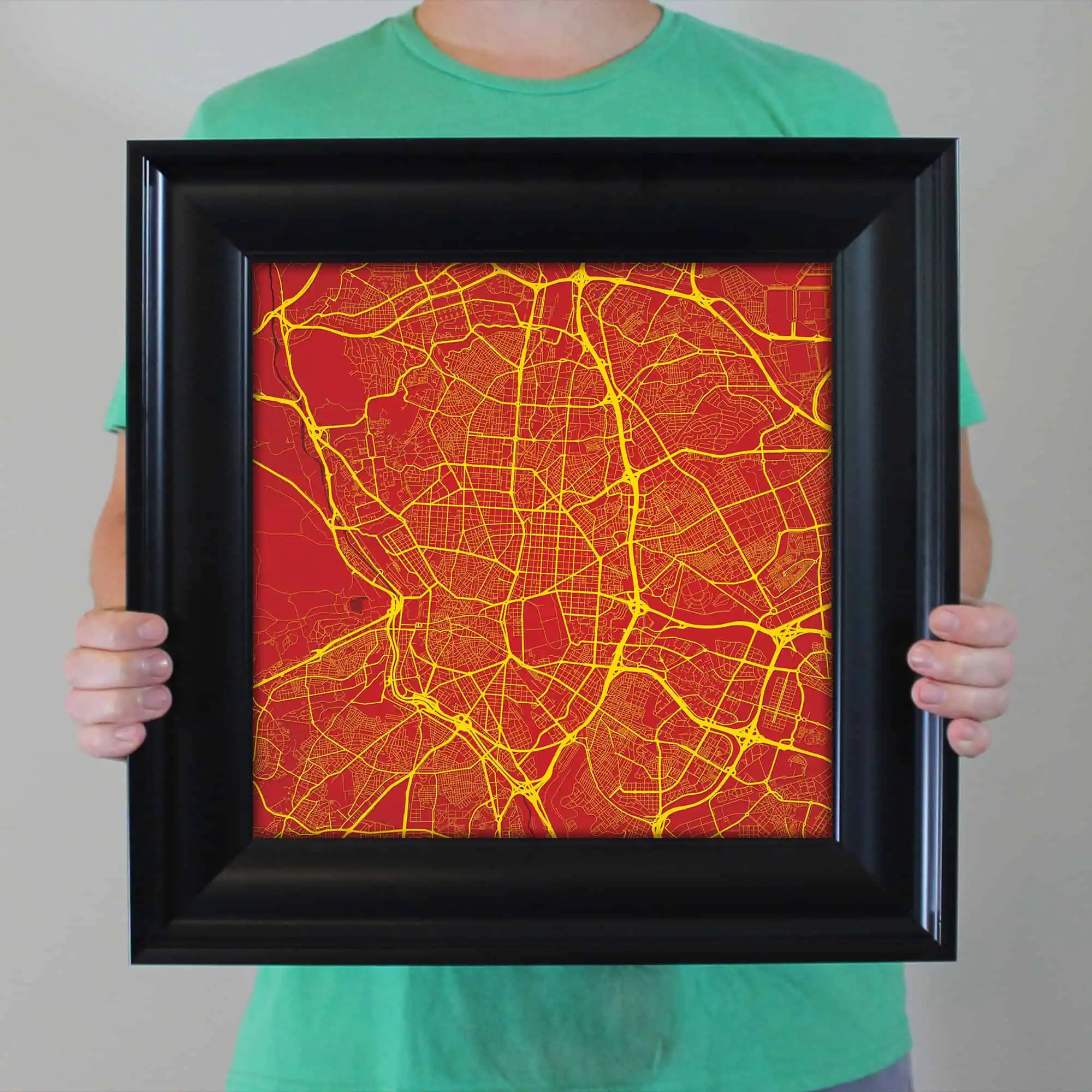 Detailed map of a city with yellow roads on a red background, framed for display, highlighting urban navigation routes.