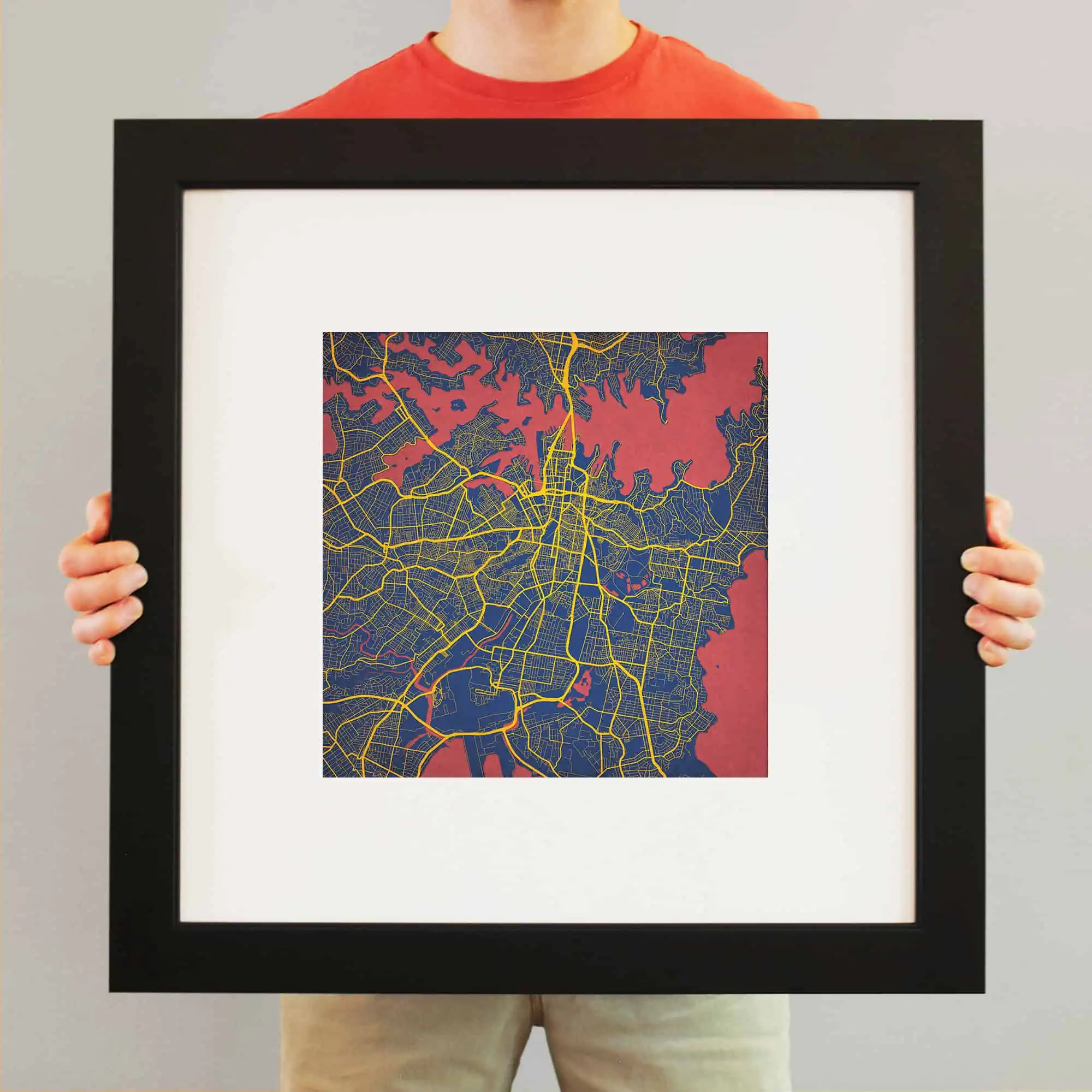 Colorful city map artwork in a black frame, showcasing detailed street layouts and waterways, perfect for home decor or travel enthusiasts.