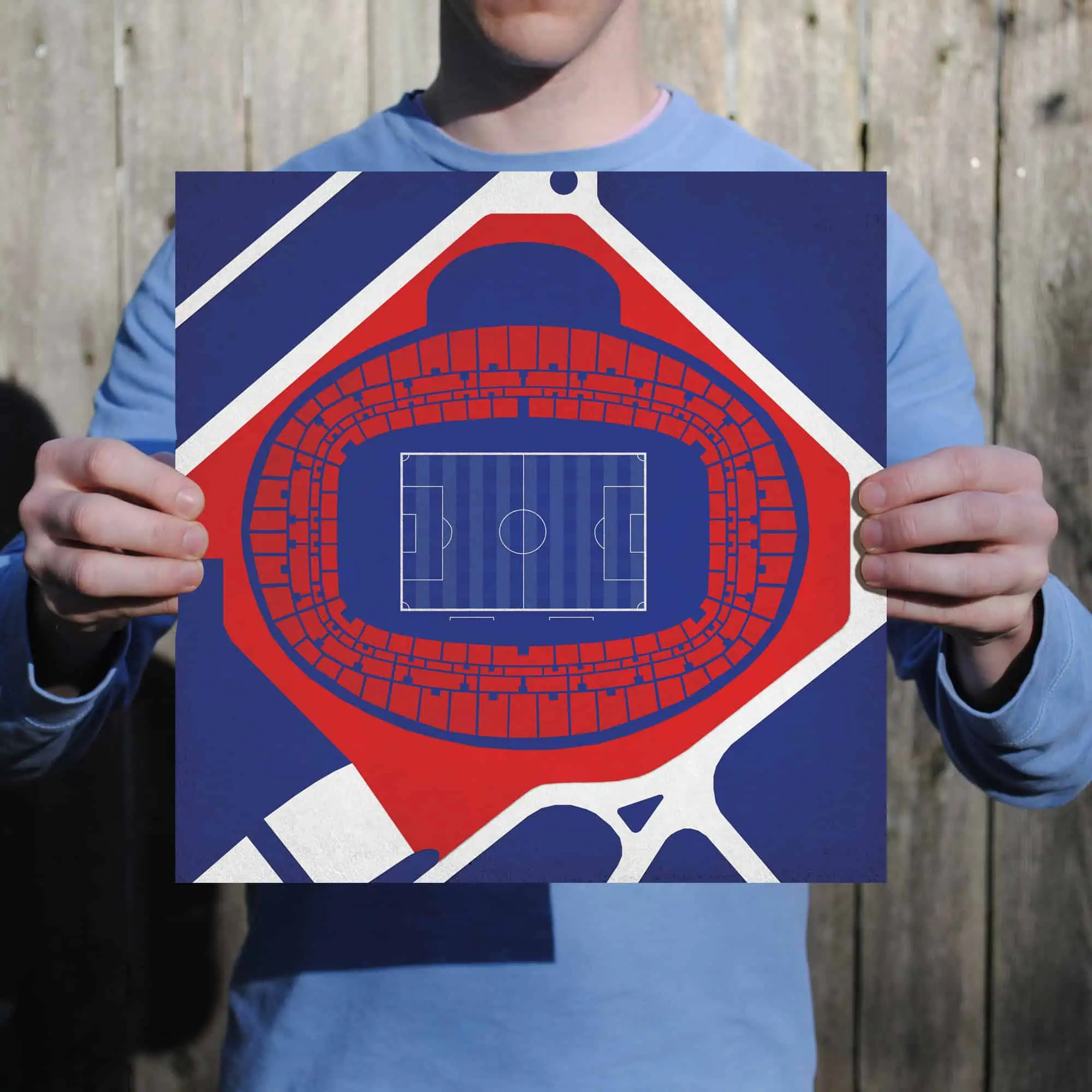 A person holding a colorful map of a football stadium with field layout, seating sections, and entrance points, ideal for sports event planning and stadium navigation.