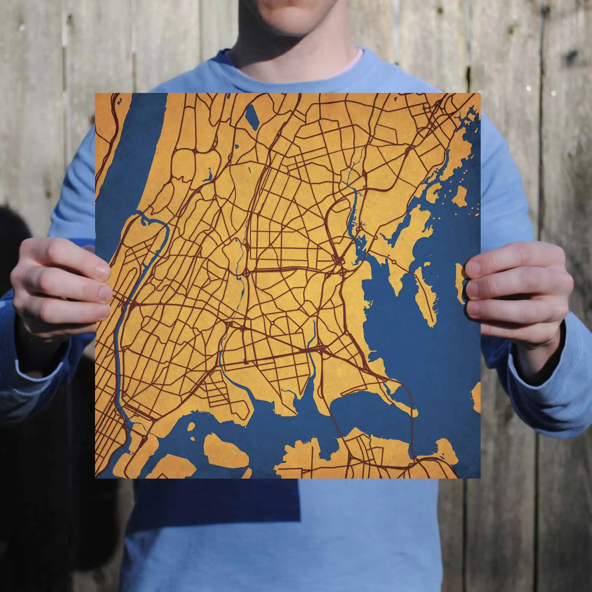 Colorful city map held by person outdoors, showcasing detailed road network and waterways, ideal for travel planning and navigation.