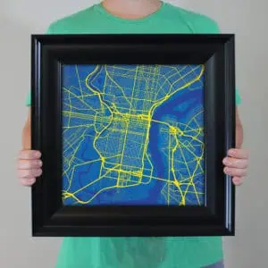 Colorful city map in a black frame, showcasing detailed street layouts and waterways for navigation and travel planning. Ideal for map enthusiasts and travelers.