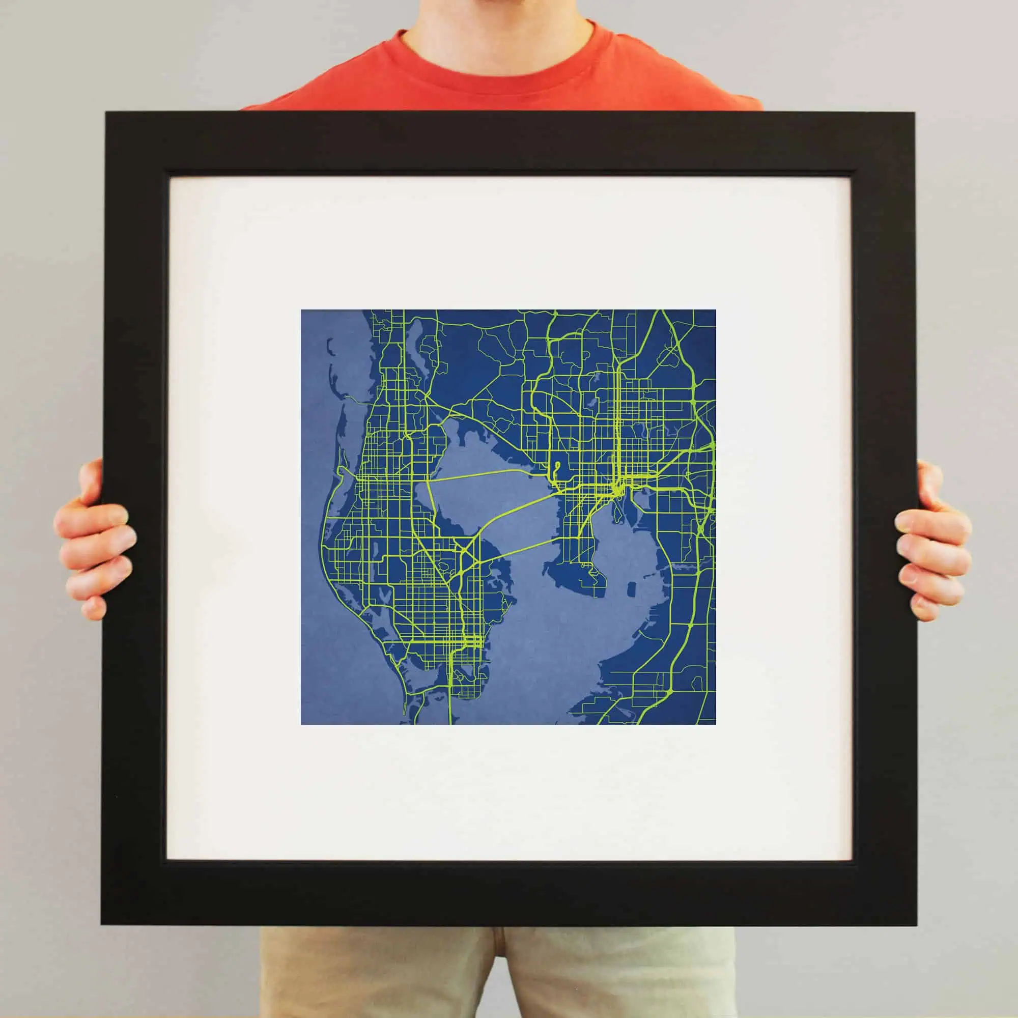 A detailed map of a city with green roads and streets, framed for display, representing urban navigation and map artistry.