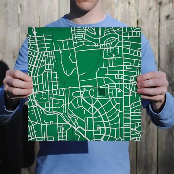 Detailed street map held by a person outdoors, showcasing cartography and navigation services from The Map Shop.