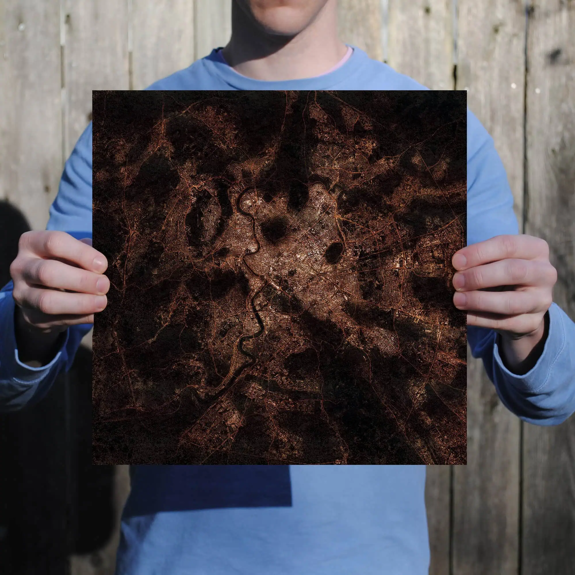 Detailed city street map printed on a square poster held by a person outdoors, showcasing urban navigation, maps, and geographic details. Perfect for travel planning, cartography enthusiasts, and geographic reference.