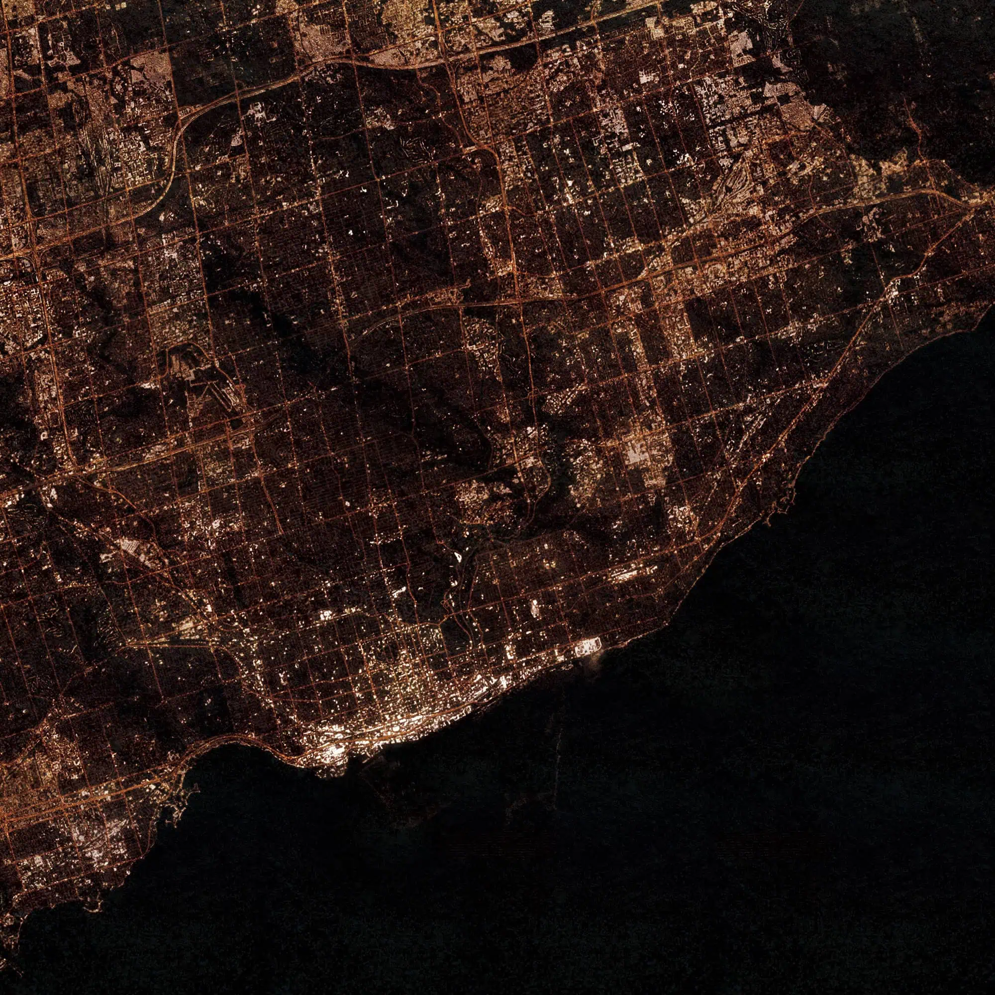 Night aerial view of a coastal city illuminated with streetlights and urban infrastructure, showcasing detailed city maps and navigation routes, perfect for map enthusiasts and travelers.
