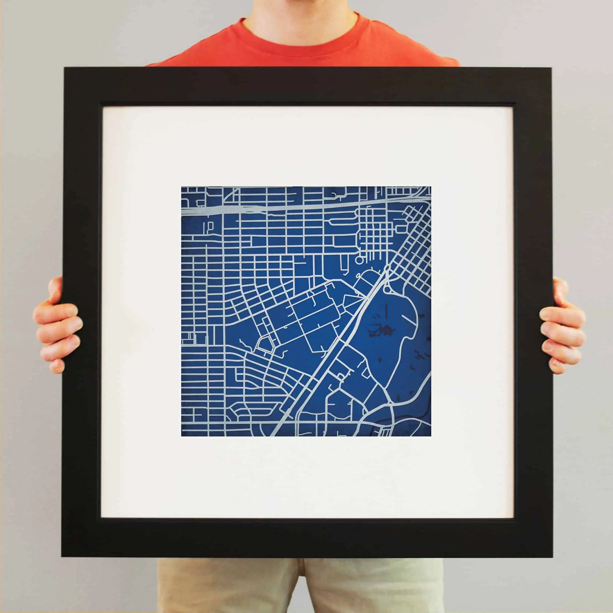 A framed map of a city with detailed street layouts, suitable for home or office decor, illustrating the quality and variety of maps available at The Map Shop.