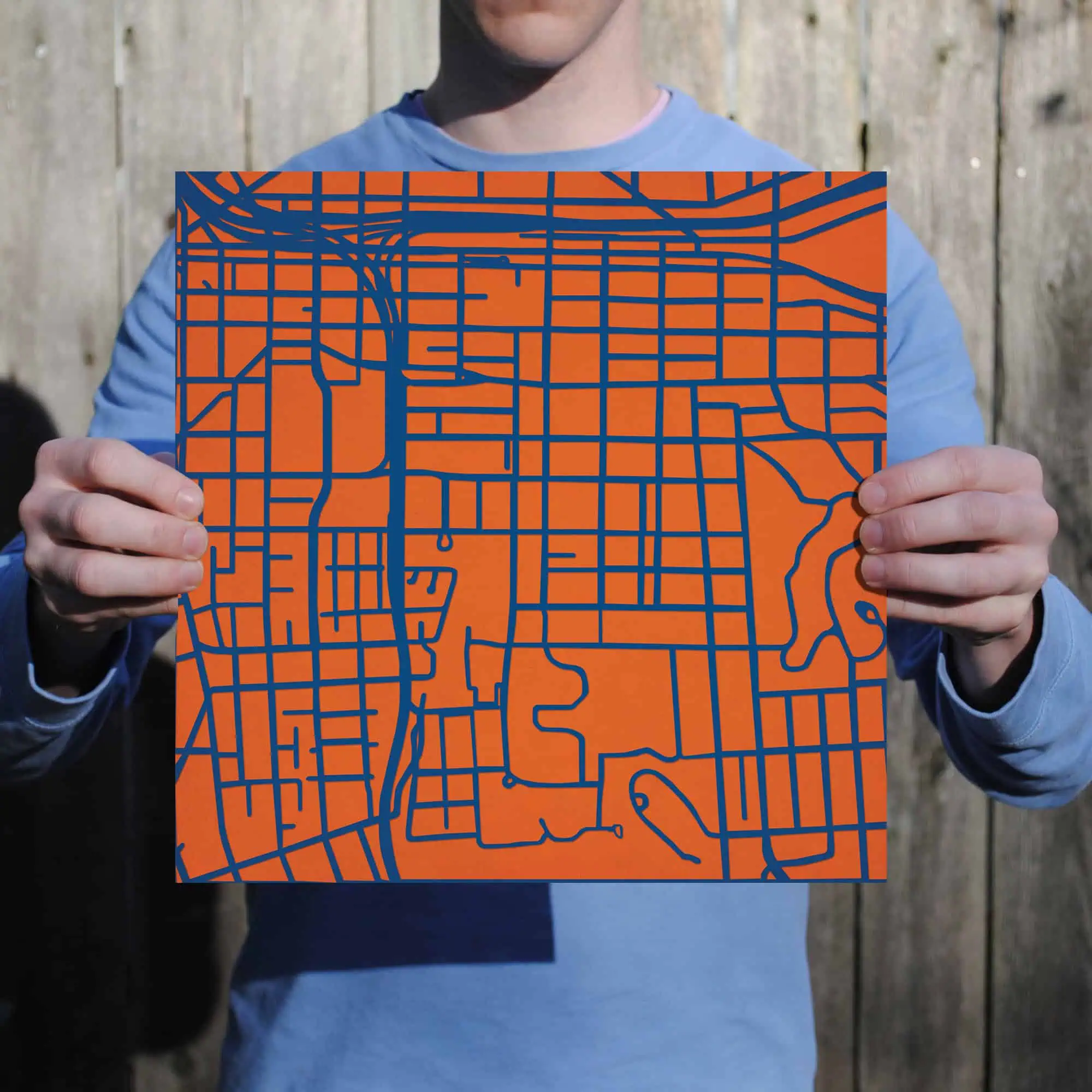 Colorful urban map held by a person, showcasing detailed city street layout and geographic features, ideal for travelers, outdoor enthusiasts, or map enthusiasts.