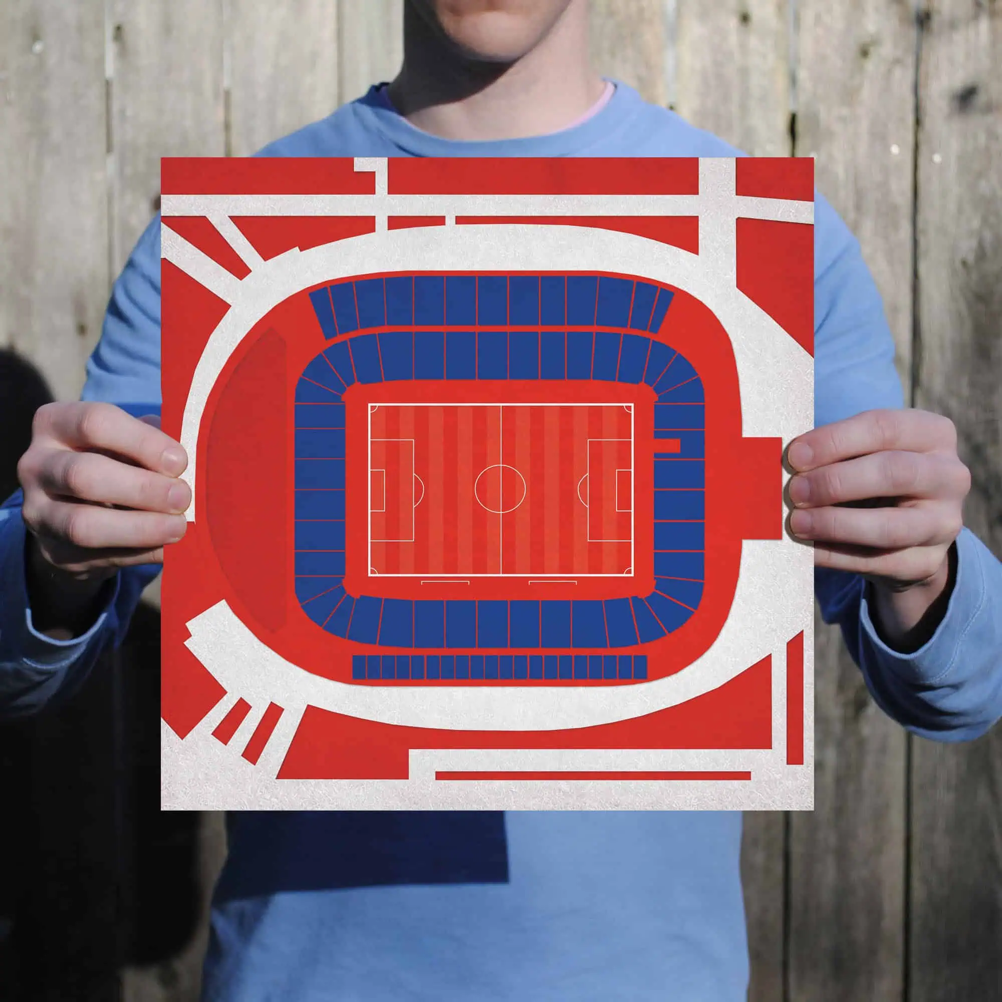 A person holding a colorful map of a sports stadium with seating and field layout, ideal for sports venue maps and stadium navigation.