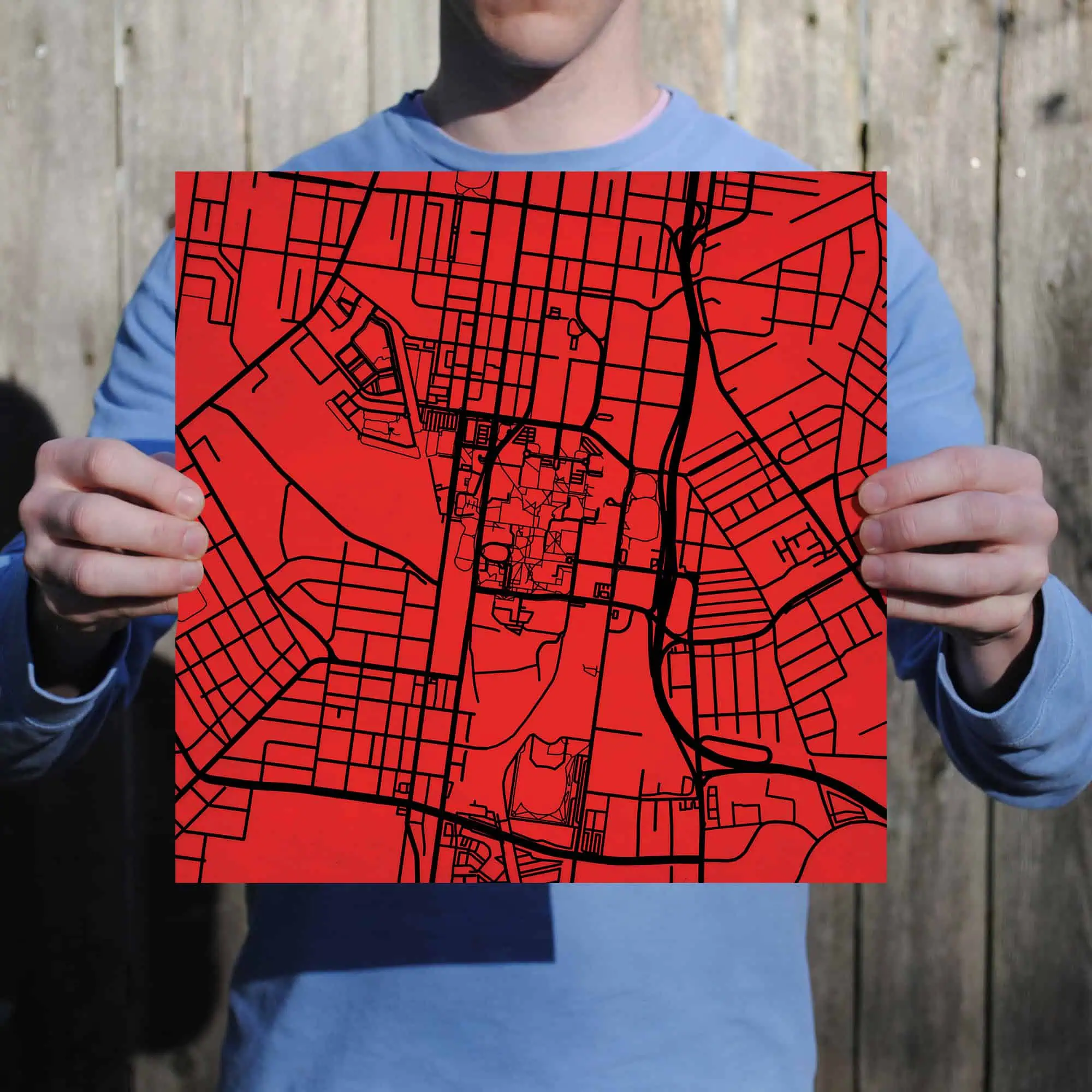 Map of downtown area held by a person in casual clothing, showcasing detailed city street layout.