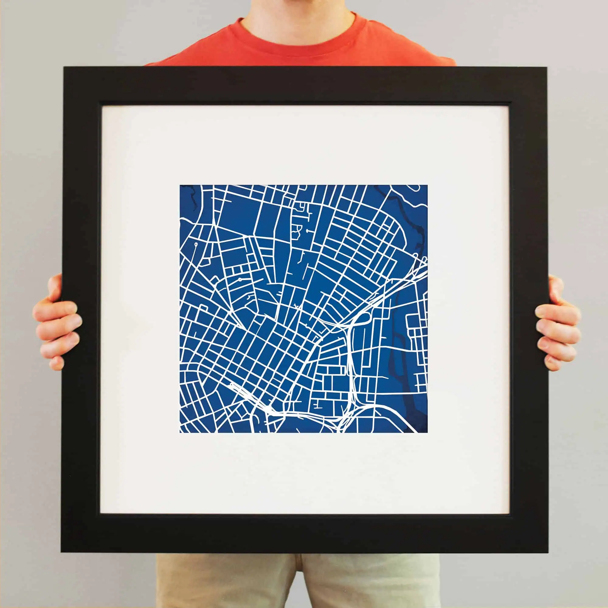 A framed map art piece featuring a detailed blue and white city street map, ideal for home or office decor, showcasing cartography and navigation themes.